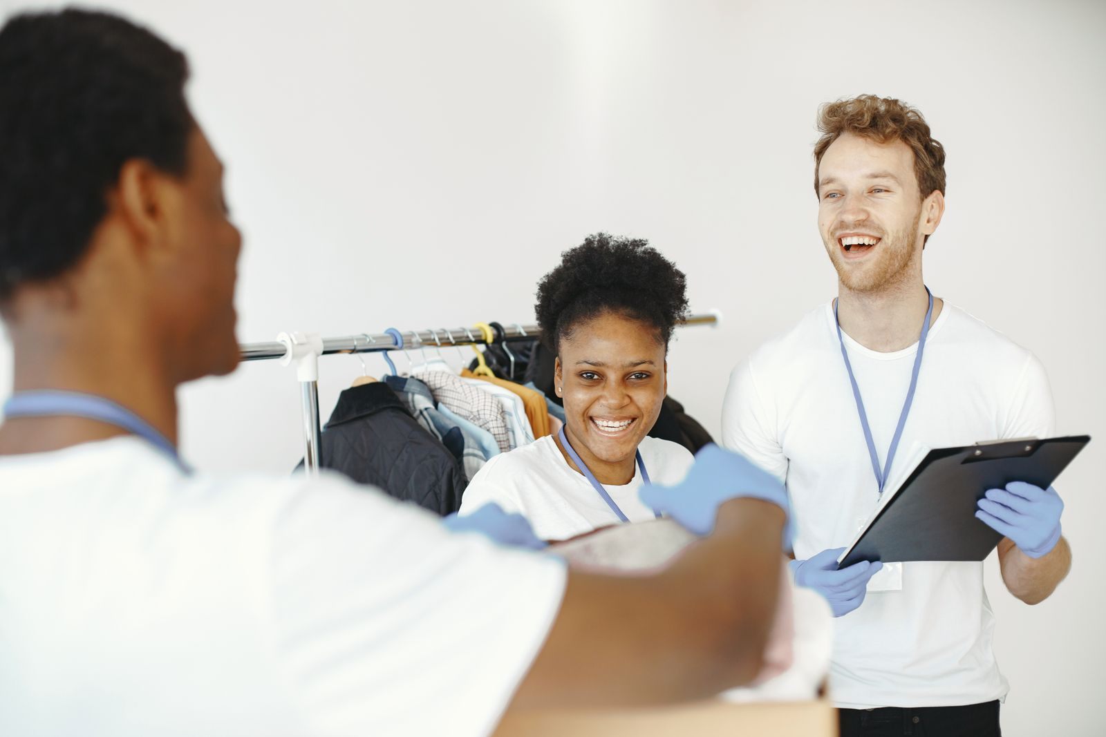 Happy volunteers organizing donated clothes, showing teamwork and collaboration in a community effort